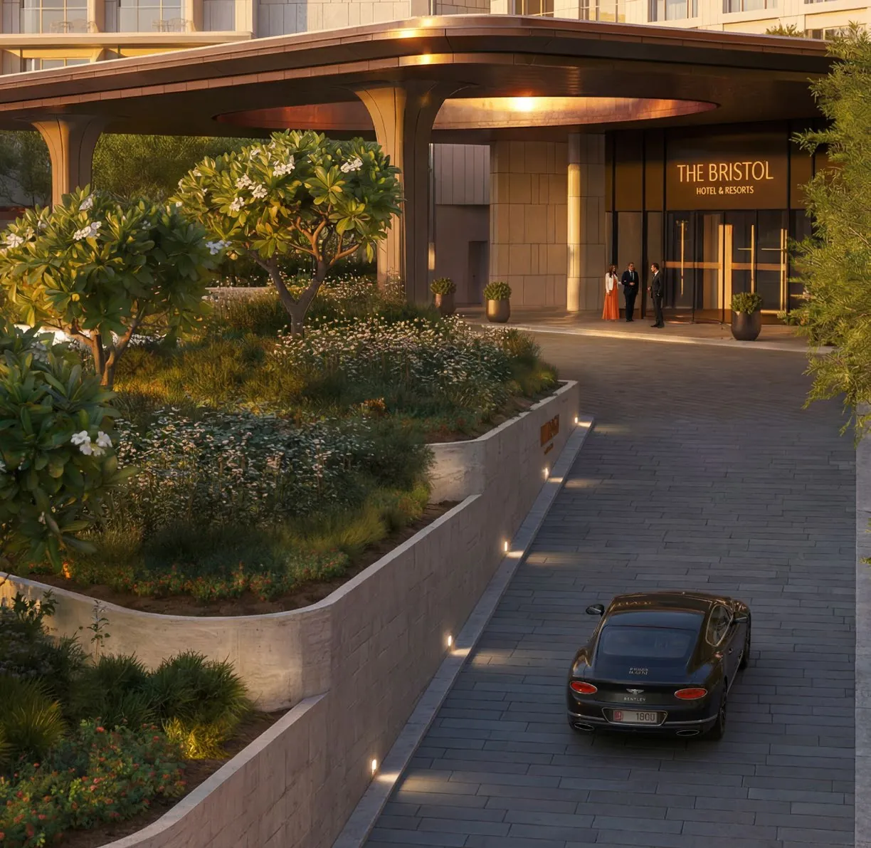 Evening arrival at The Bristol Hotel: a lit canopy over the entrance, planted terraces and a car on the curving drive